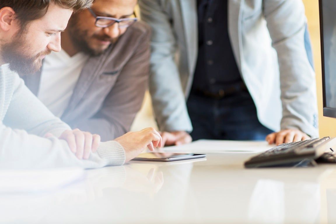 Picture of 3 men at a desk looking at a tablet. Looking for a Brio alternative?